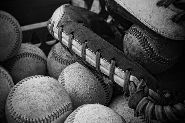 야구공-여러개가-야구배트와-함께-놓여있는-모습의-흑백사진
