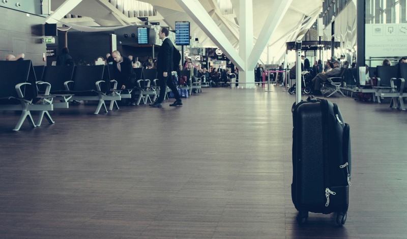 A quiet airport boarding area with a single suitcase standing alone, symbolizing early departure and independent travel for study abroad.