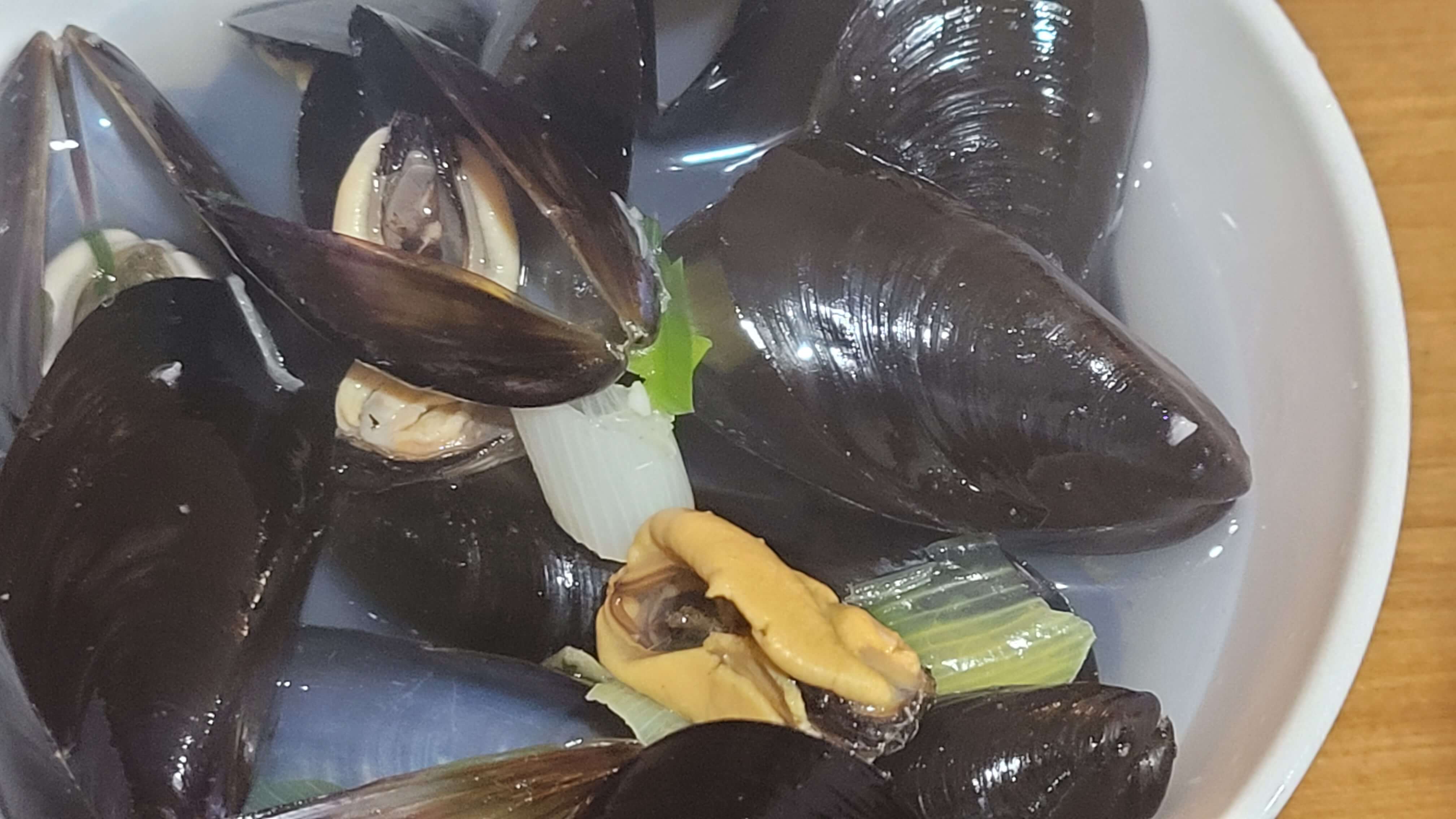 겨울 제철 식재료인 홍합과 파를 준비한 홍합탕 레시피용 그릇, 간단한 집밥 요리 강조