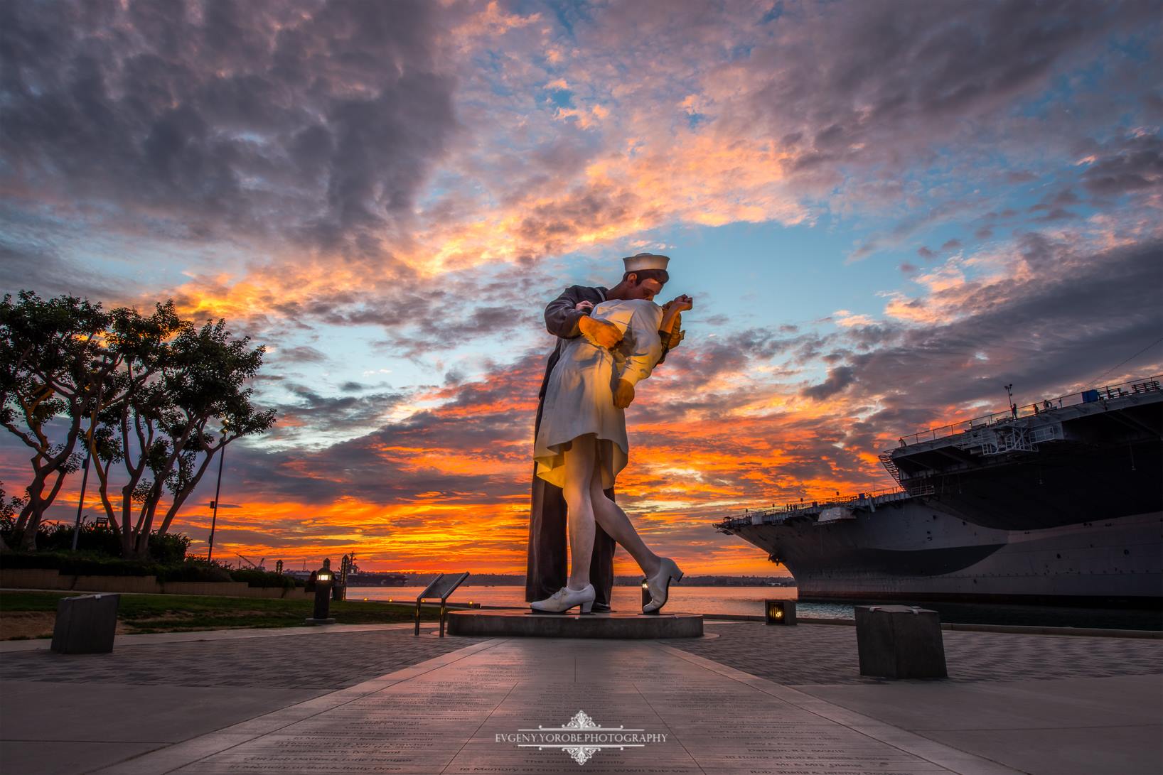 &#39;빛의 키스(Kiss of Light)&#39;&#44; 타오르는 석양이 비친 &#39;무조건 항복 조각상&#39;을 찍은 사진(The Unconditional Surrender statue captured with a fiery sunset.)&#44; 조각상은 캘리포니아 주 샌디애고 항구에 설치되어있다. - 출처 : The San Diego Union-Tribune&#44; Photograph by Evgeny Yorobe Photography