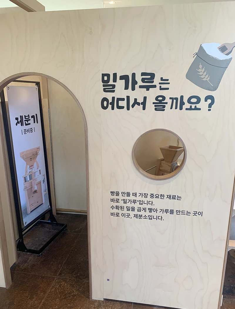 밀가루는 어디서 올까요? 문구와 함께 나무 가판이 있는 체험시설