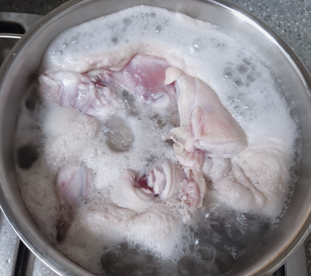 닭을 끓이는데 거품이 올라오고 있다.