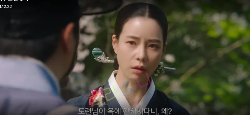 검은색 한복을 입고 단정히 묶은 머리를 태영이 진지한 표정으로 만석이를 바라보고 있다. 배경에는 나무가 가득한 숲길이 보인다. 자막은 