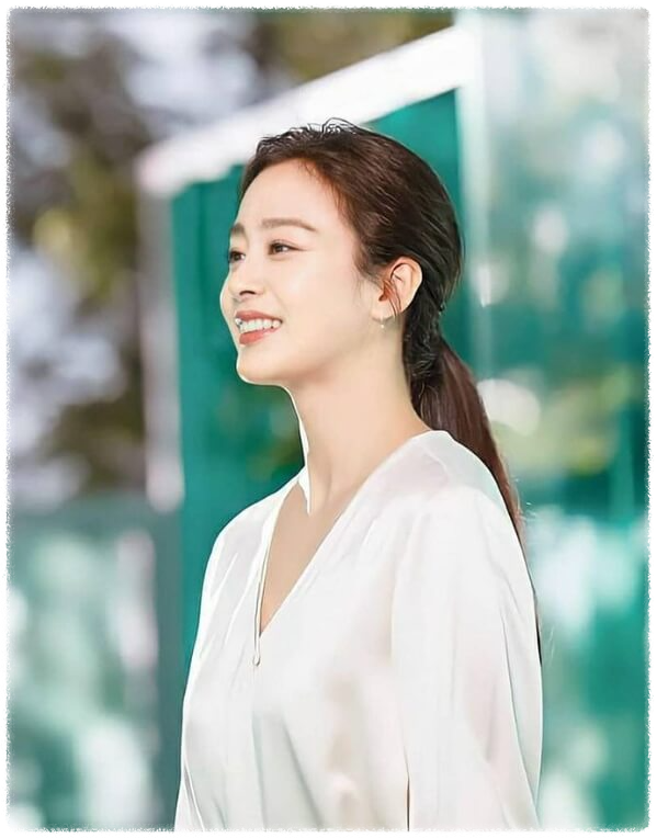 배우 김태희의 옆모습. 흰 옷을 입고 살짝 웃고 있다.