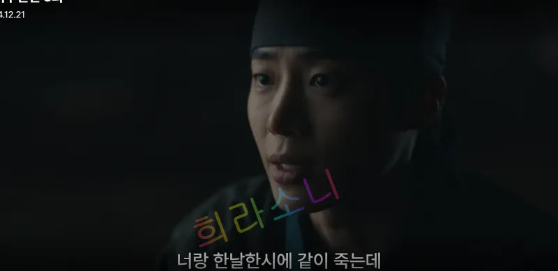 승휘가 검은 두건을 쓰고 결연한 표정으로 상대방에게 말하고 있다. 화면 하단 자막에는 &amp;quot;너랑 한날한시에 같이 죽는데&amp;quot;라는 문구가 적혀 있다.