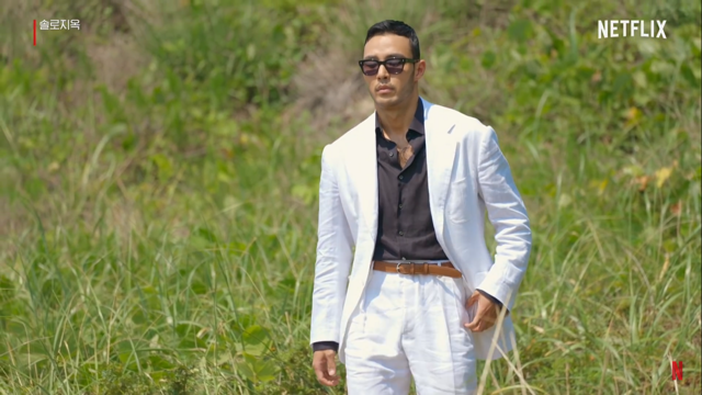 출연자 중에 가장 털이 많은 남자가 흰 정장에다 안에는 검은색 남방을 입고 등장하는 사진입니다