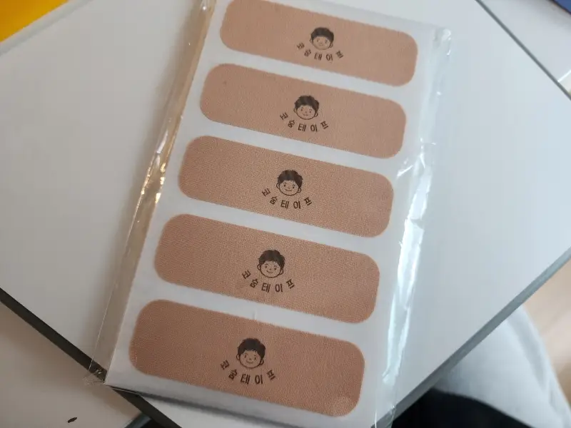 코숨테이프라는 제품명과 마스코트인 코네 얼굴이 그려져 있는 살색의 테이프 본품. 하얀색 바탕지에 5개씩 붙여져 있다.