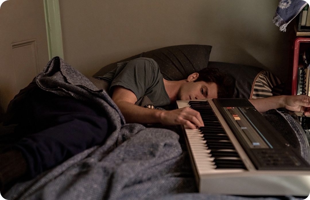 피아노를 만지며 누워 있는 남자 사진