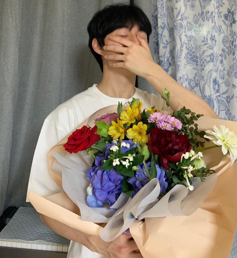 윤찬영 인스타그램 꽃을 들고 입을 가린채 웃고 있는 사진