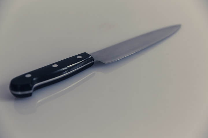흰색-테이블-위에-검은-손잡이의-날카로운-칼이-올려져있는-모습