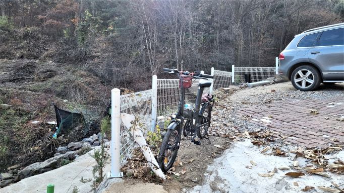 농원 주차장 하얀 철망 기둥에 매어놓은 자전거&#44; 우측에 승합차 뒷부분&#44;