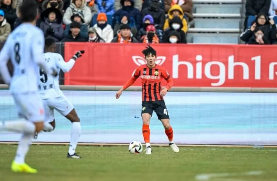 축구장 붉은색과 검은색이 섞인 유니폼을 입고 축구공을 차고 있는 양민혁