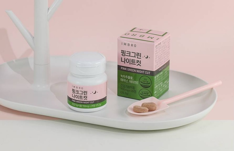 핑크그린-나이트컷-분홍색-원통형-패키지와-분홍색-종이상자-패키지와-진한-오트밀색상-알약-두-개