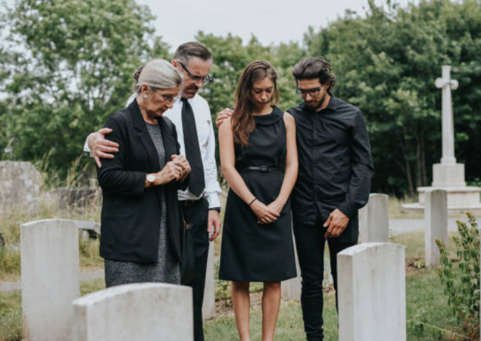 장례식-비석-앞에서-묵념하는-가족