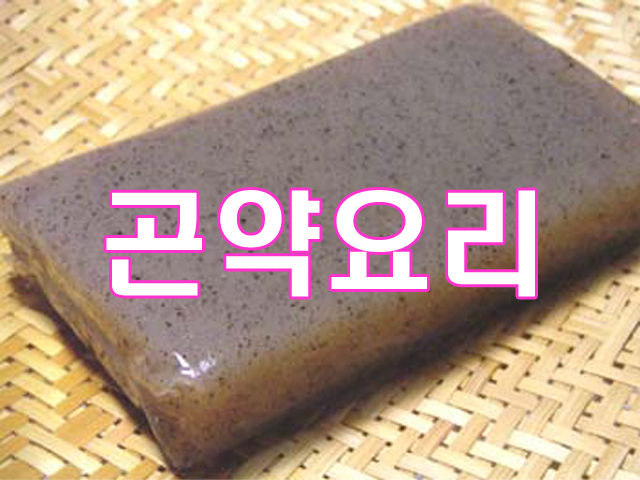 나무-채반에-올려진-회색-바탕에-검은-점-무늬의-큰-곤약-덩어리