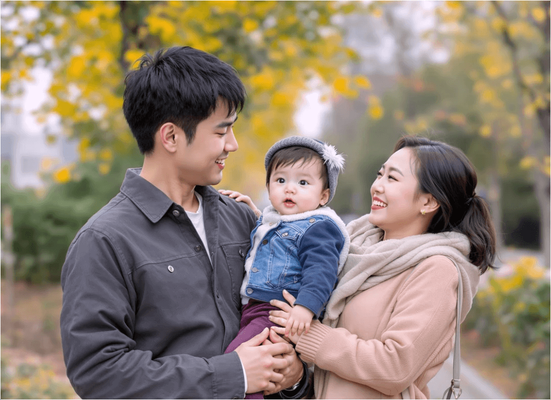 거리에서 엄마와 아빠가 함께 아이를 안고 웃고 있습니다.