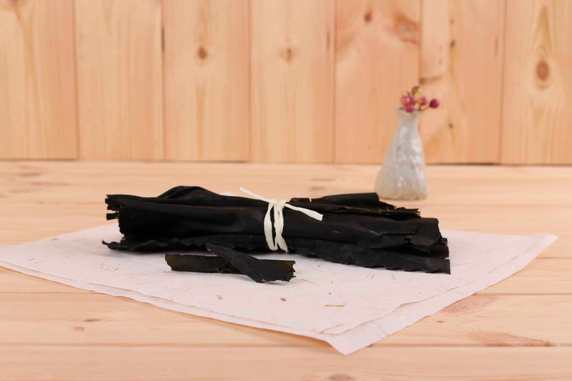 seaweed-2499345_1920 바다에서 채취를 한 다시마를 잘 세척해서, 잘 건조한 후에 여러 개를 모아서, 종이 끈으로 묶어서, 깨끗한 종이 위에 올려 놓고, 뒤에는 작은 화병에 꽃을 담아 놓은 사진