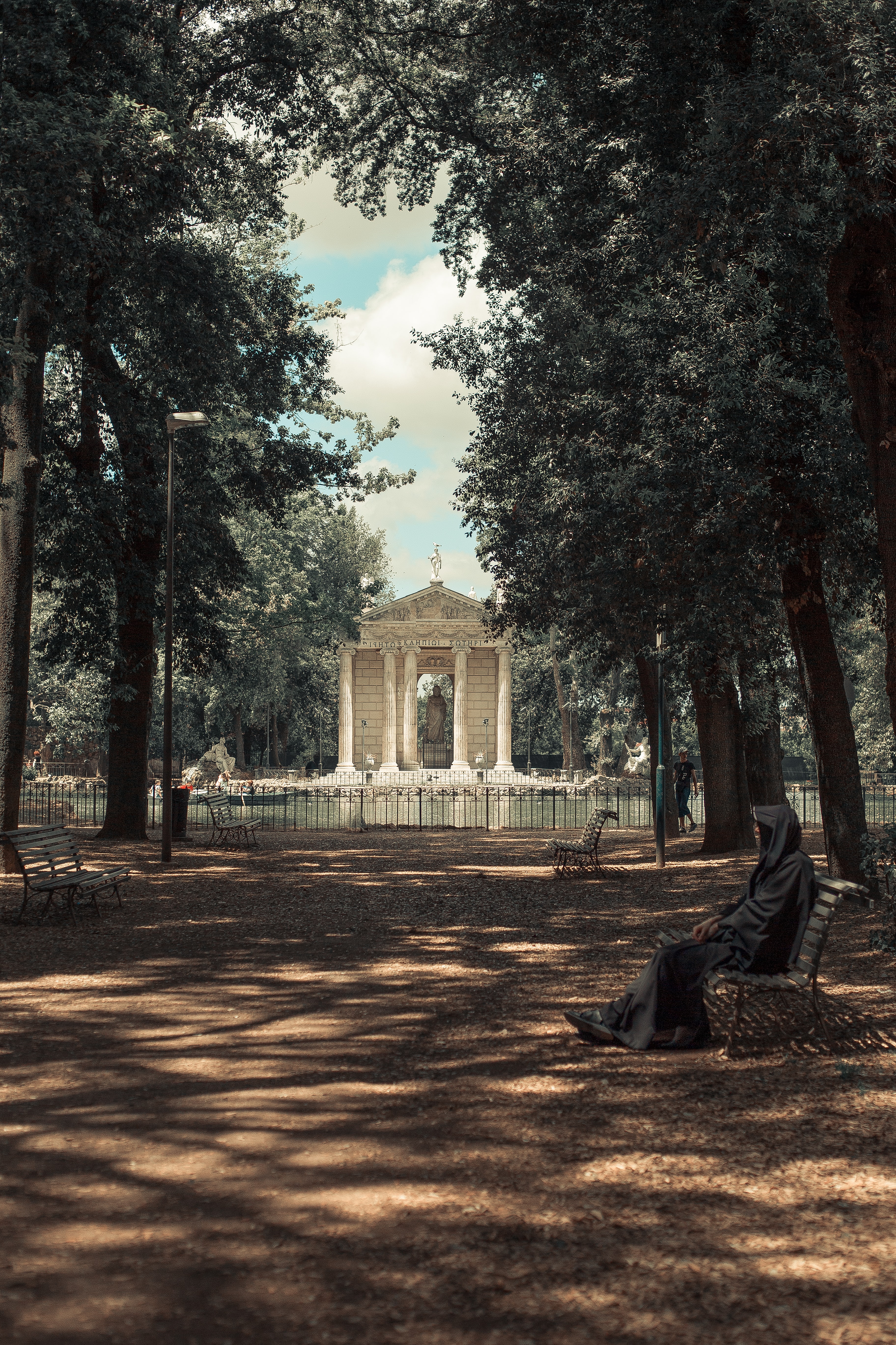 이탈리아 로마의 한 공원에서 나무들이 즐비하고 한 가운데 로마의 작은 신전이 서있는 모습
