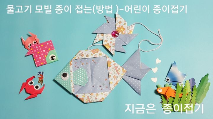 물고기 모빌 접기 방법으로 만든 연푸른색의 모빌 완성 모양이며&#44; 바람개비 접기를 줄의 중간에 달아준 모양입니다.