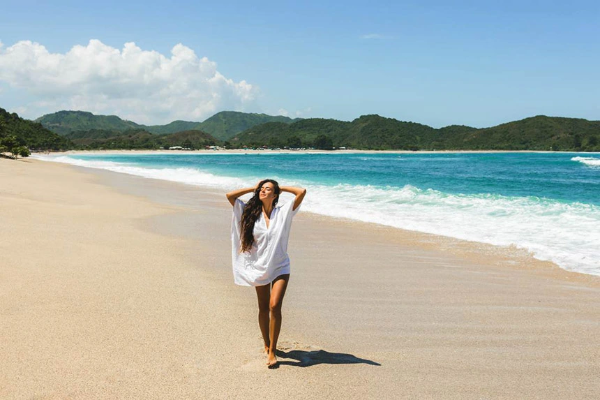 비치웨어를 입고 해변에 서 있는 여성 모델