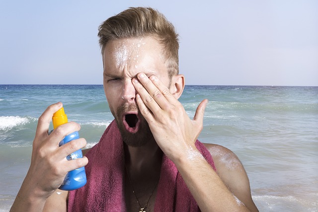 이것은 해변에서 선크림을 바르고 있는 남자의 사진입니다.