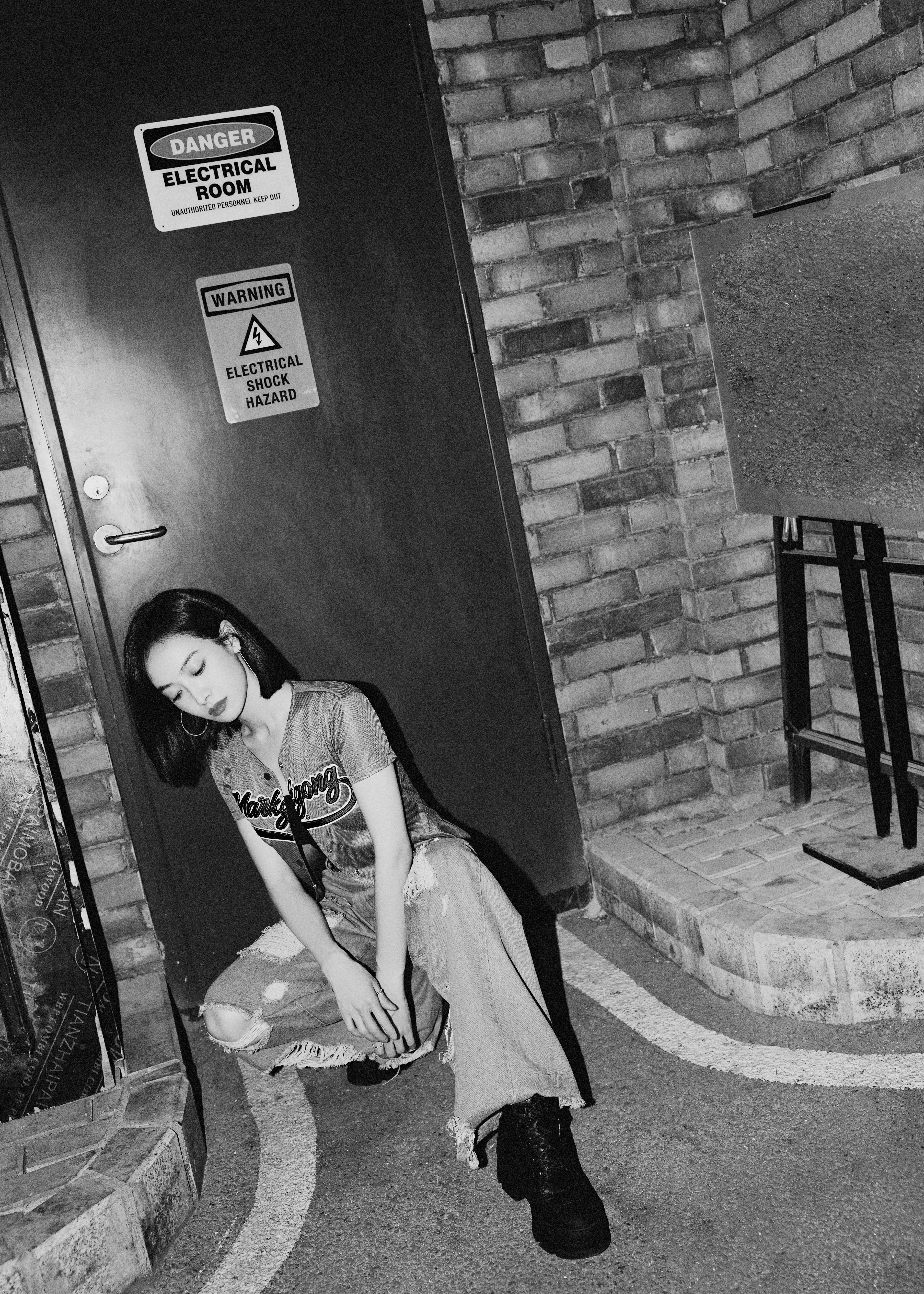 쪼그려 앉은 송치엔의 흑백 사진