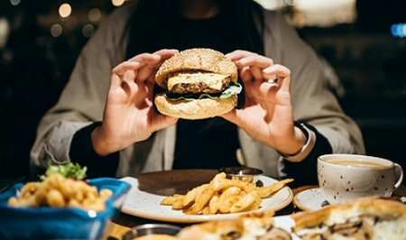 당뇨병의 환경적 요인중 과식을 나타내는 햄버거와 각종음식을 먹는사진