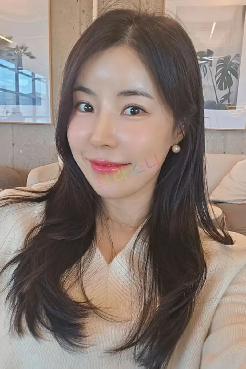 10기 영숙이 화사한 조명 아래에서 아이보리색 블라우스를 입고 부드러운 미소를 지으며 카메라를 응시하고 있다. 그녀는 자연스러운 긴 웨이브 머리를 내리고 있으며&amp;#44; 진주 귀걸이를 착용하고 있다. 배경에는 클래식한 오디오와 꽃이 놓여 있는 테이블이 보인다. 자막에는 &amp;quot;희라소니&amp;quot;라는 텍스트가 보인다.