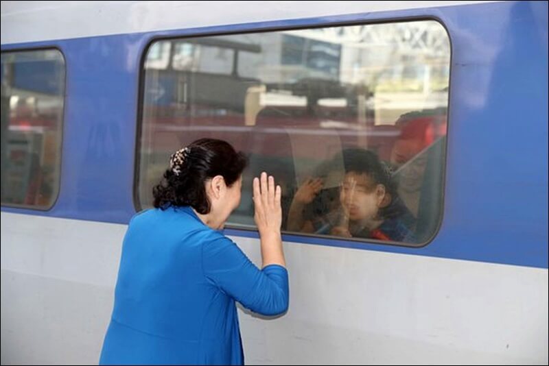 ktx 열차 밖에서 창문을 보며 손을 흔들며 배웅을 하는 여성