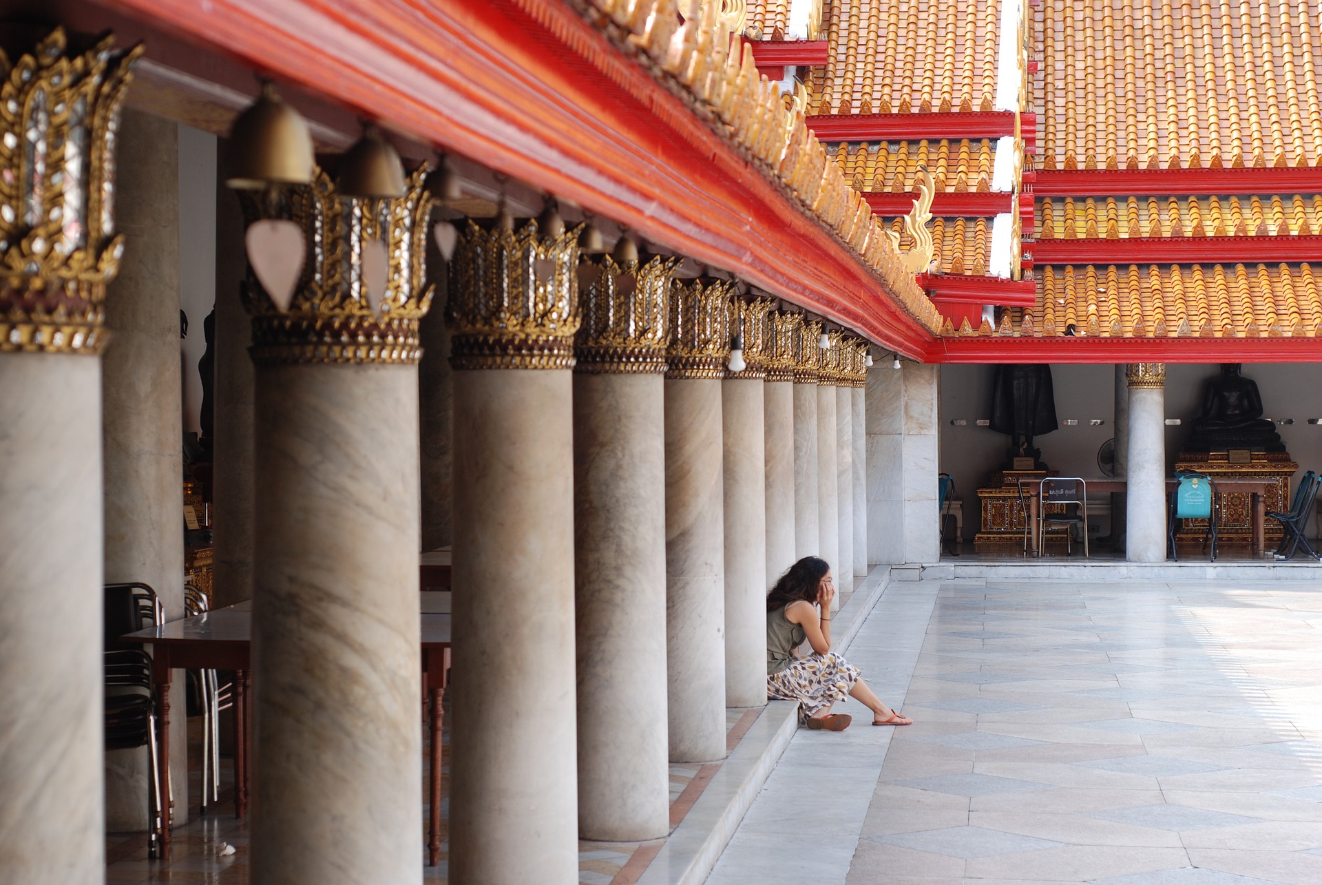 태국 방콕의 왕궁에서 한 여자가 앉아서 기다리고 있음