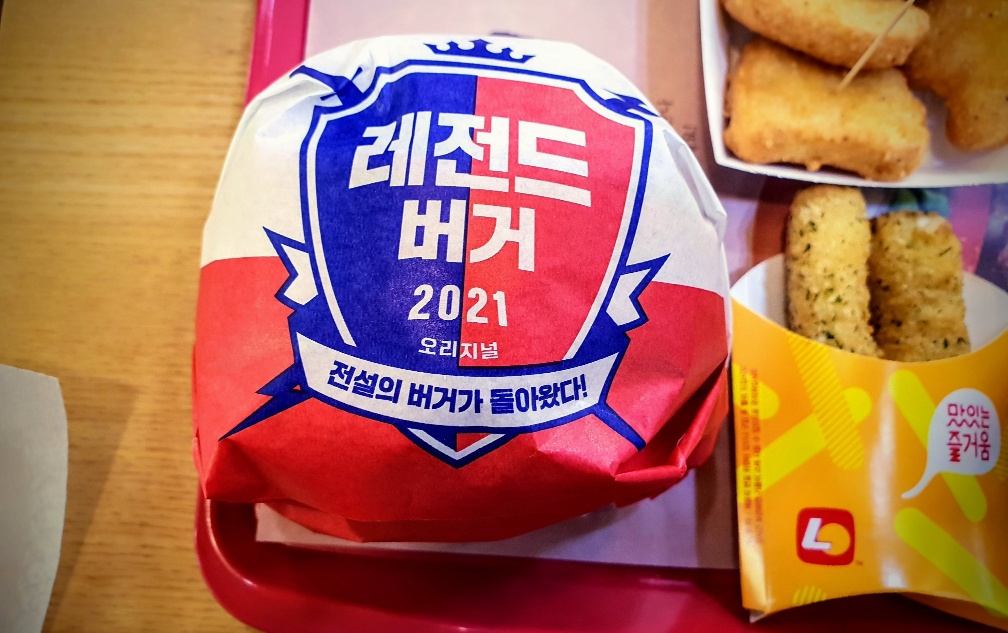 유러피안 프리코 치즈버거를 레전드 버거라고 적혀 있는 종이로 감싸고 있는 사진