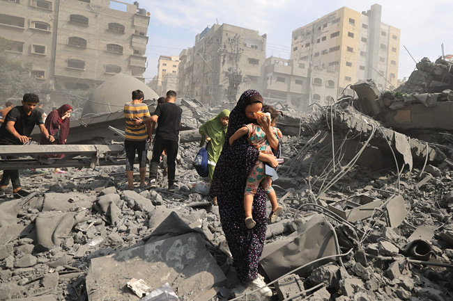 9일(현지시간) 가자지구에서 폭격을 맞은 모스크를 헤치고 팔레스타인인들이 대피하고 있다. AFP 연합뉴스