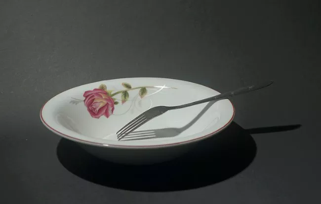 빈 접시 위에 포크만 놓여있는 모습
