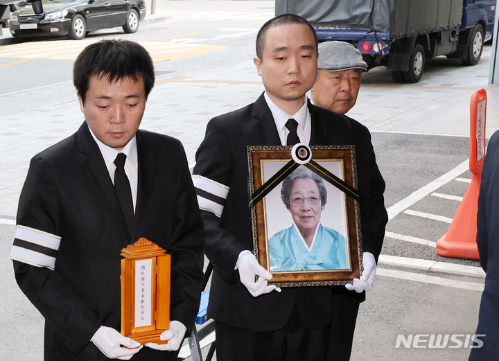 19일 오전 서울 강동구 강동성심병원 장례식장에서 엄수된 박종철 열사의 어머니 고 정차순 여사의 발인에서 손자 박영주 씨가 영정을 들고 있다. 오른쪽은 아들 박종부 씨. 출처 뉴시스