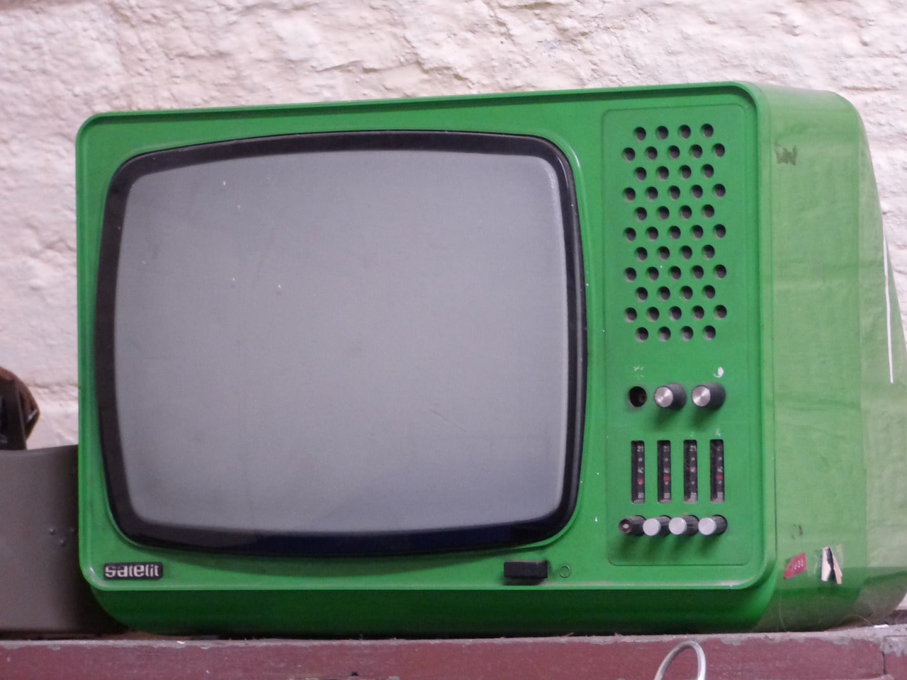 초록색 tv가 책상위에 있는 사진
