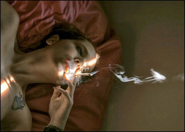 여성이 누워서 흡연하고 있는 모습