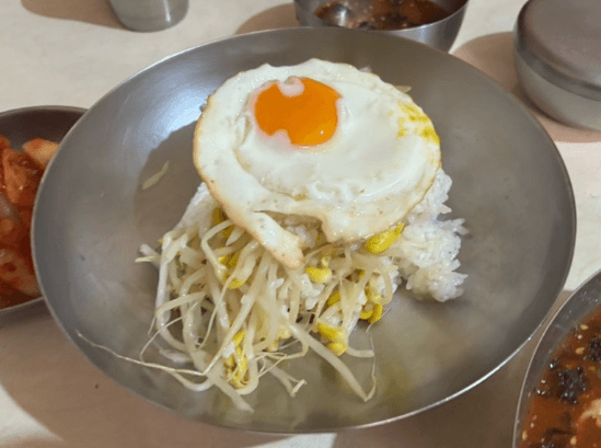 콩나물밥: 신선한 콩나물과 반숙 계란후라이가 올라간 담백한 맛의 밥입니다.