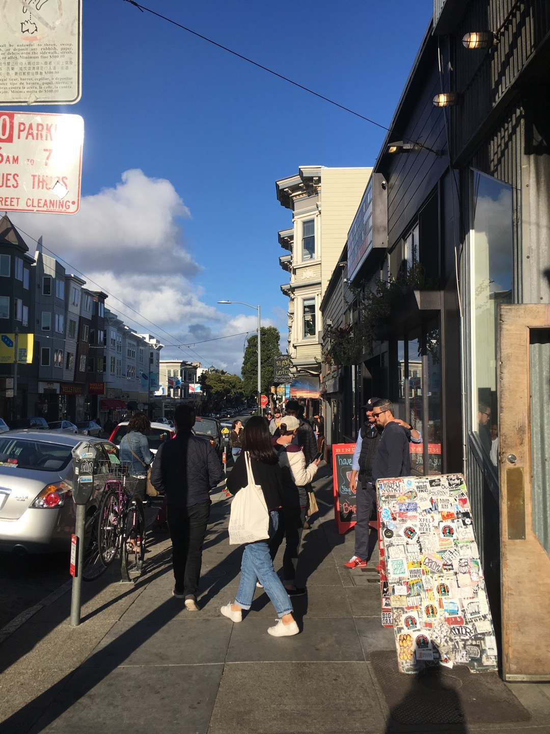 crowded haight street with a lot of people in sunny day