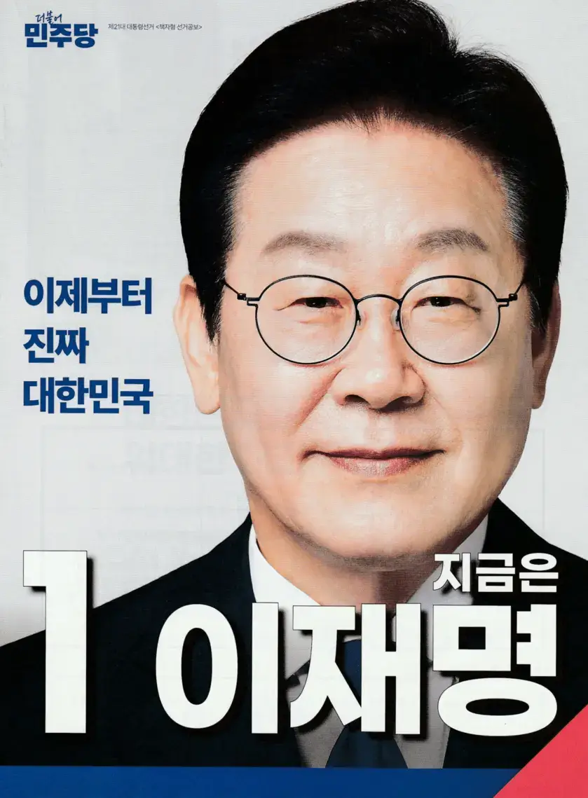 더불어민주당 이재명 후보의 제21대 대선 캠페인 포스터로&amp;#44; &amp;#39;지금은 이재명&amp;#39;이라는 슬로건과 함께 2025년 대선 메시지를 전달하는 이미지