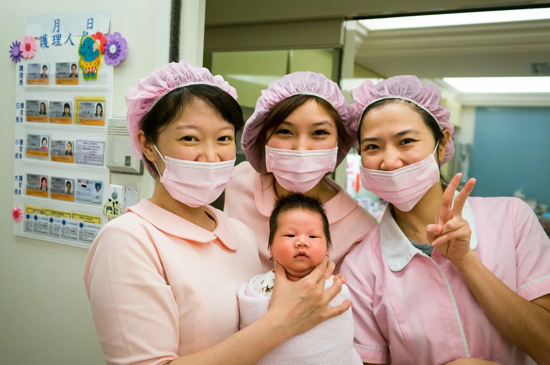 아기를-들고-아기와-함께-사진을-찍고-있는-3명의-간호사