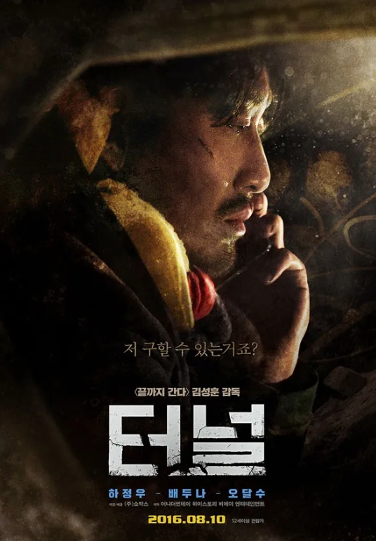 차 안에 갇혀서 슬픈 표정을 짓고 있는 남자가 휴대폰으로 어딘가에 전화를 하고 있다