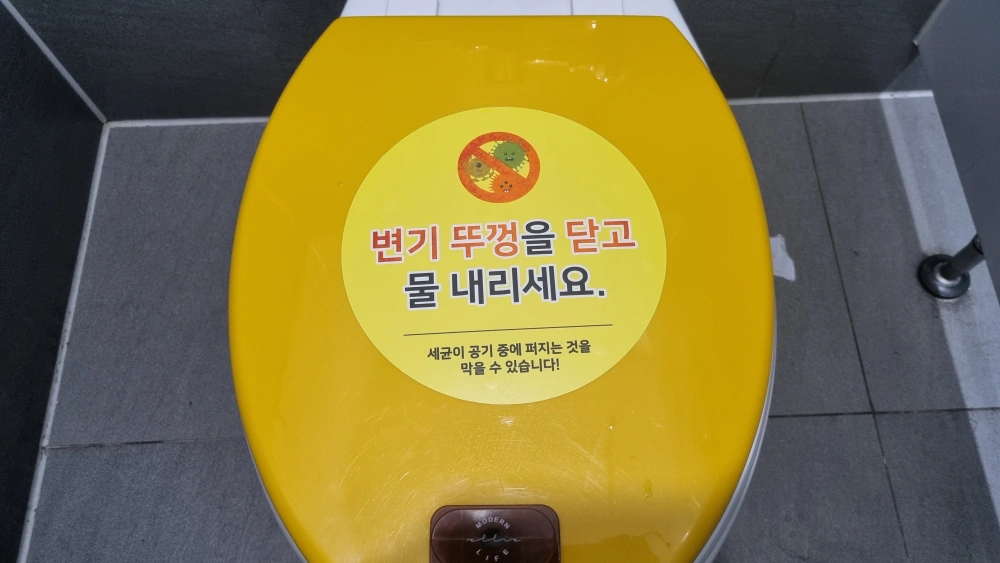 변기 뚜껑 닫고 물을 내리세요 라고 적혀있다
