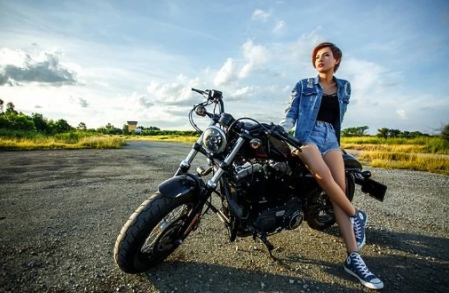 오토바이에 기댄 여성 사진