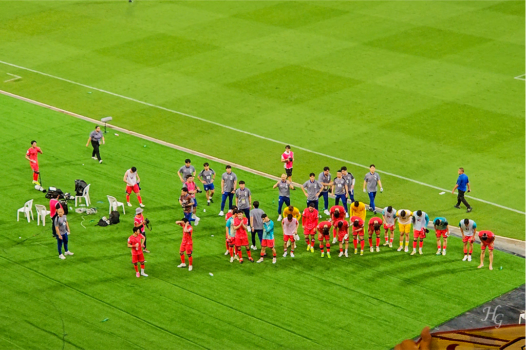 한국인 관중석을 향해 인사하는 붉은 유니폼의 한국 선수단