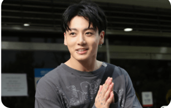 정국이 팬들 앞에서 합장하는 모습으로 미소 지으며 인사하는 모습