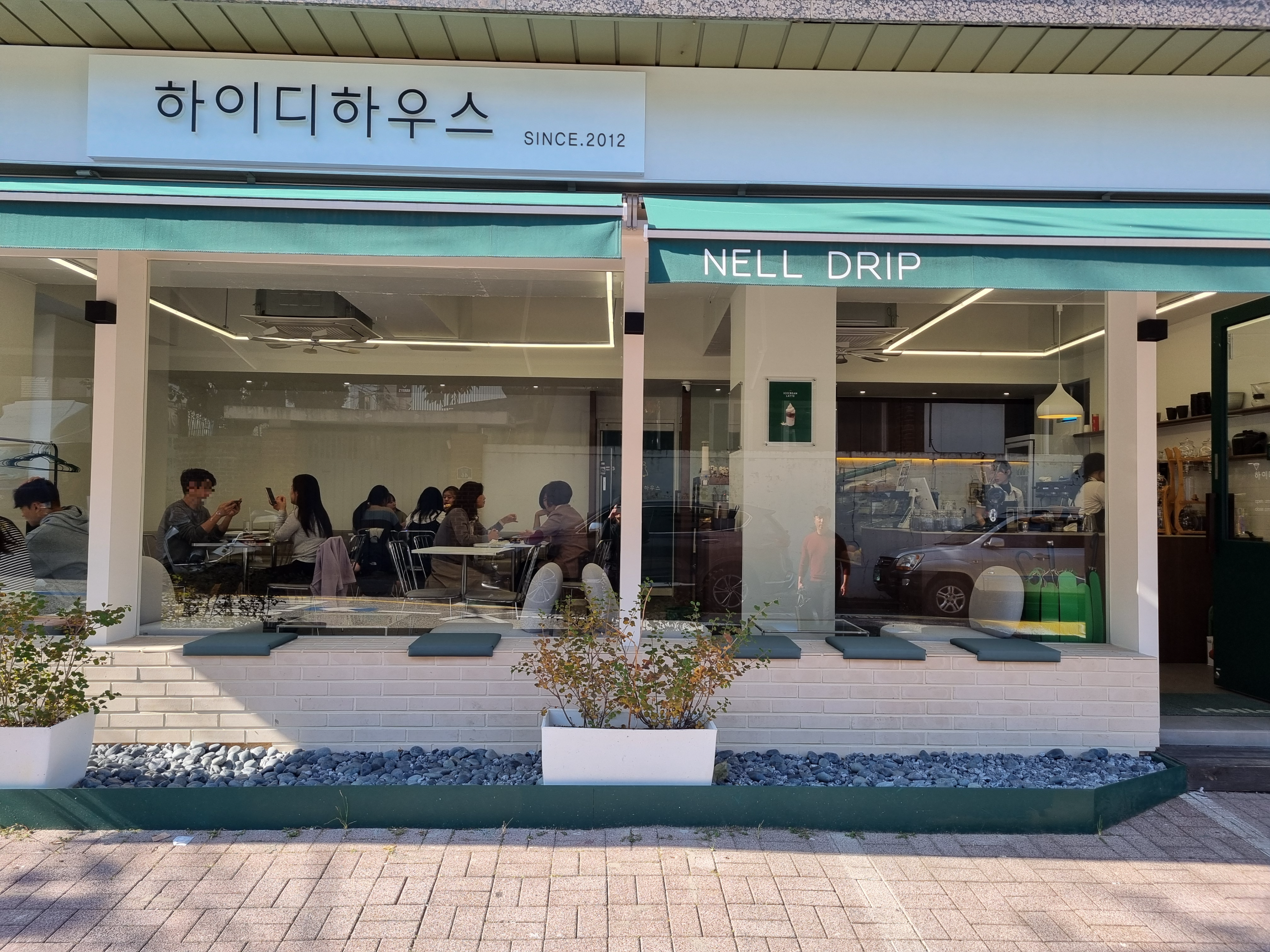 통유리 너머로 보이는 화이트톤의 아늑한 카페