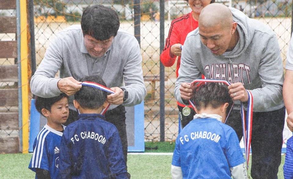 차범근 차두리가 차범근축구교실 원생들에게 메달을 수여하는 모습의 사진