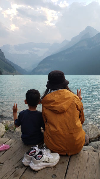 호수에 엄마와 아들이 앉아있는 뒷모습