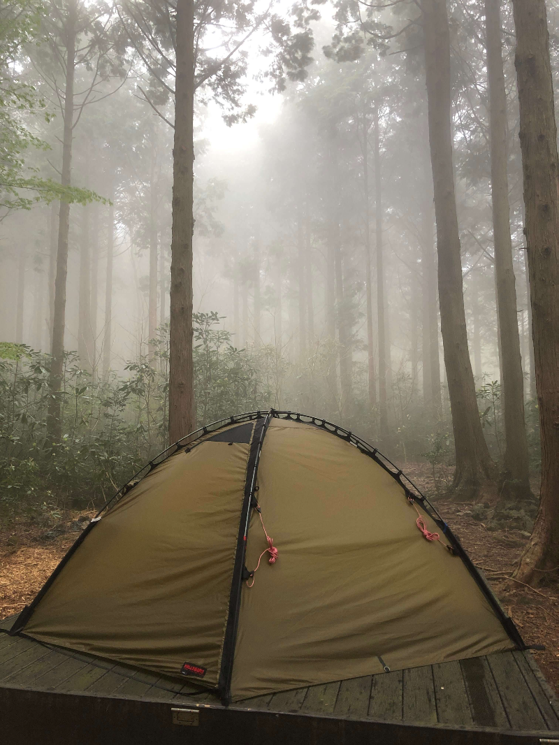 안개 낀 숲 가운데 텐트의 모습