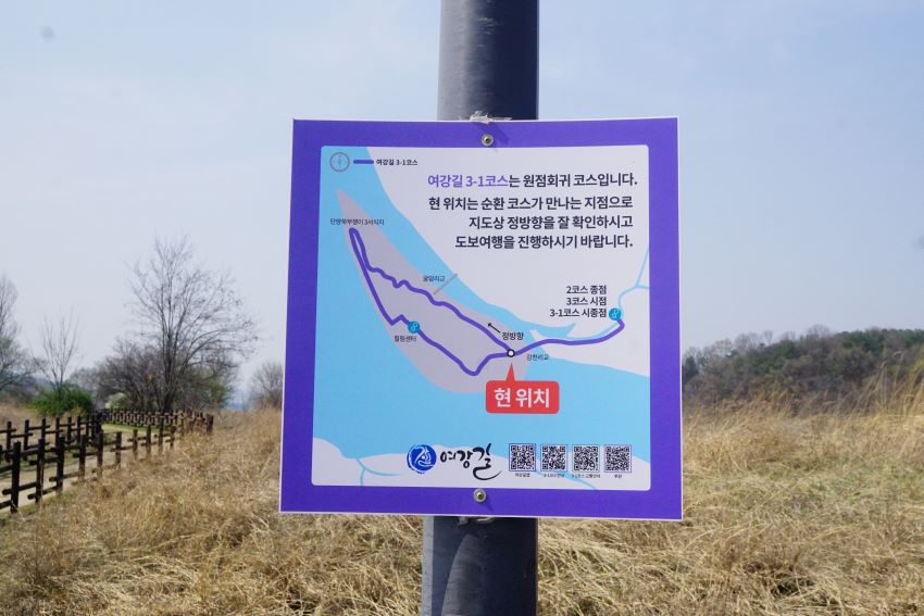 여강길 안내도, 사각 흰바탕에 검은 글씨, 보라색 테두리, 현위치 표시, 부착된 기둥 뒤로는 푸른 하늘,